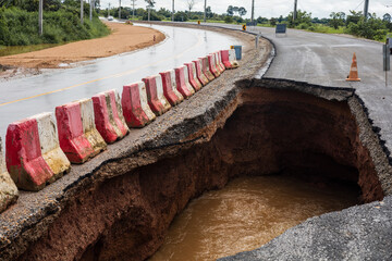 The road was destroyed by water erosion caused by heavy rain and flooding the road.