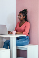 Afro business woman working with laptop in a coworking place.