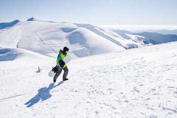 Fototapeta na wymiar man snowboarder at the top of the mountains