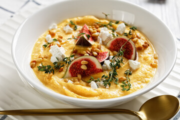 Pumpkin soup with feta, figs, pine nuts, top view