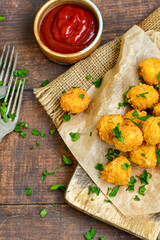 
 Crispy  deep fried home made    chicken  nuggets .Breaded  with  almond flour chicken  breast fillets  with chilly peppers and fresh   basil on wooden rustic background. Ketogenic diet food