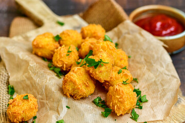 
 Crispy  deep fried   chicken   popcorns  Breaded  with cornflakes chicken  breast fillets  with chilly peppers and fresh   basil on wooden rustic background