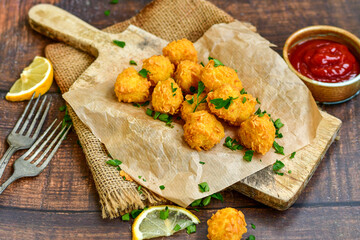 
 Crispy  deep fried home made    chicken  nuggets .Breaded  with  almond flour chicken  breast fillets  with chilly peppers and fresh   basil on wooden rustic background. Ketogenic diet food