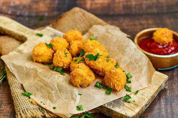 
 Crispy  deep fried   chicken   popcorns  Breaded  with cornflakes chicken  breast fillets  with chilly peppers and fresh   basil on wooden rustic background