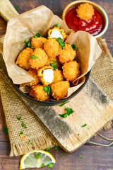 
 Crispy  deep fried   chicken   popcorns  Breaded  with cornflakes chicken  breast fillets  with chilly peppers and fresh   basil on wooden rustic background