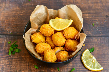
 Crispy  deep fried   chicken   popcorns  Breaded  with cornflakes chicken  breast fillets  with chilly peppers and fresh   basil on wooden rustic background