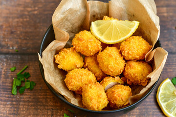 
 Crispy  deep fried   chicken   popcorns  Breaded  with cornflakes chicken  breast fillets  with chilly peppers and fresh   basil on wooden rustic background
