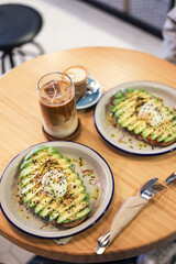 breakfast of avocado toast with egg and coffee with milk