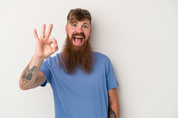 Young caucasian ginger man with long beard isolated on white background cheerful and confident...