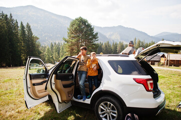 Two brothers eat apples at vehicle interior. Traveling by car in the mountains, atmosphere concept.