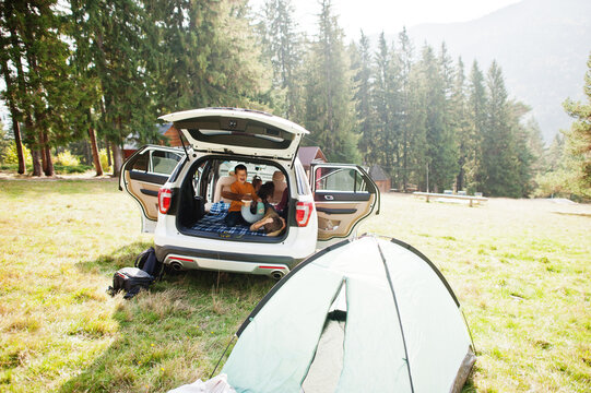 Two Brothers Fighting Pillows At Vehicle Interior. Children In Trunk. Traveling By Car In The Mountains, Atmosphere Concept.