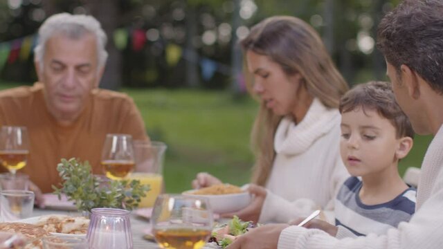 Tracking Shot of Family Serving Up Food During Outdoor Dinner 01