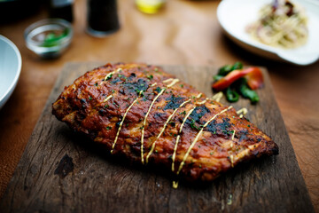 Closeup of pork ribs steak on wooden board food styling