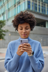 Millennial hipster girl messages via mobile application uses smartphone connection on leisure...