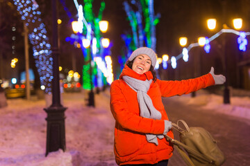 Obraz premium Young pretty funny girl having fun outdoor in winter. Christmas, city and winter holidays concept.