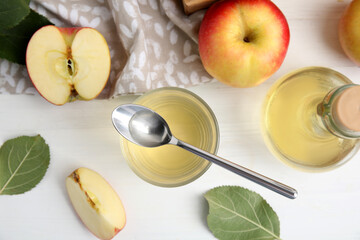 Natural apple vinegar and fresh fruits on white wooden table, flat lay