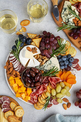 Appetizers boards with assorted cheese, meat, grape and nuts.