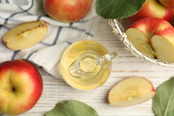 Natural apple vinegar and fresh fruits on white wooden table, flat lay
