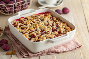 Plum streusel cake in white baking dish