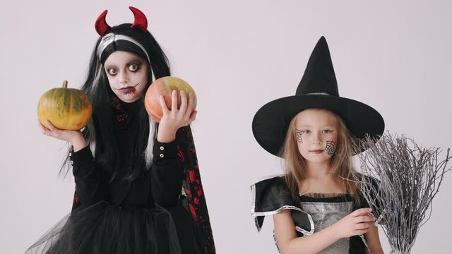 Group of kids in halloween costumes having fun on white copy space