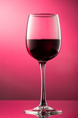 pouring red wine into glass with highlights on red background