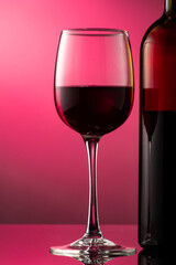 pouring red wine into glass with highlights on red background