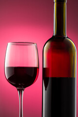 pouring red wine into glass with highlights on red background