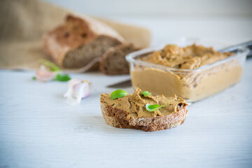 homemade liver pate with bread on a wooden table