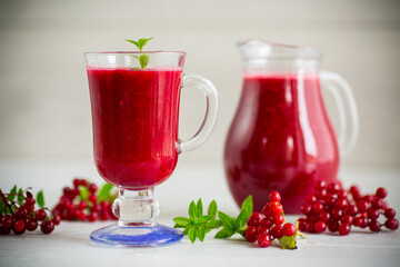 freshly squeezed thick natural juice with pulp from ripe red viburnum in a decanter