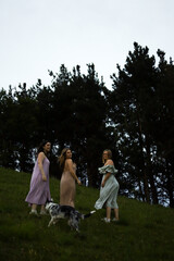 Obraz premium girlfriends smiling in nature in colorful dresses during spring