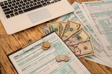 Obraz premium on the table are neatly folded American forms 1040 on which coins pen calculator