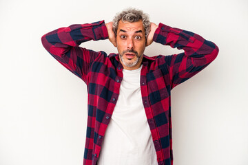 Middle age caucasian man isolated on white background  covering ears with hands trying not to hear too loud sound.