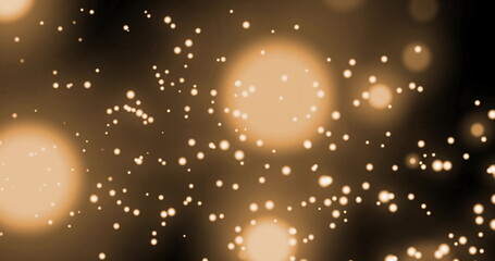 Image de plusieurs taches dorées brillantes de lumière se déplaçant en mouvement hypnotique sur fond noir