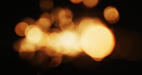 Multiple warm orange lights flickering on black background