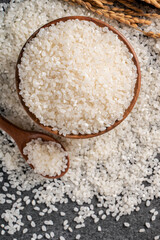 White rice in a bowl on dark black table background.