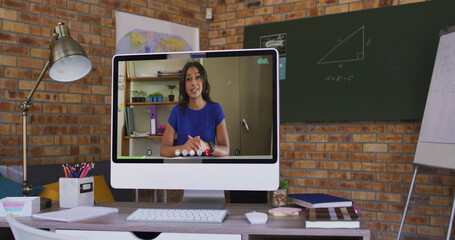 Mixed race woman having business image call on screen of computer on desk