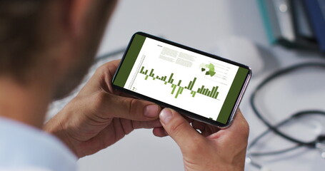 Hands of caucasian man using smartphone with statistics on screen