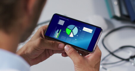 Hands of caucasian man using smartphone with statistics on screen