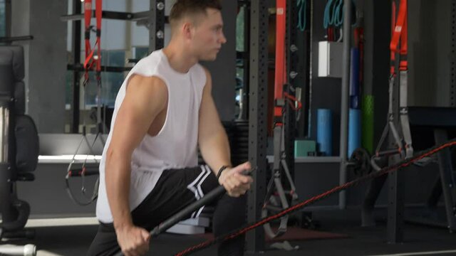 athletic male training at a fitness club with a body bar, young man working out with crossbar at the gym, healthy active lifestyle