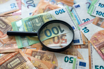 euro bills with magnifying glass, finance concept