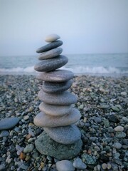 Fototapeta na wymiar stack of stones on beach at the sea bank