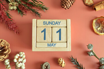 May 11, Cover design with calendar cube, pine cones and dried fruit in the natural concept.