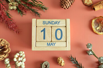 May 10, Cover design with calendar cube, pine cones and dried fruit in the natural concept.