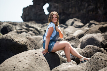Young beautiful woman sitting on the stone