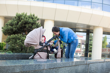 Young mother walking and pushing a stroller