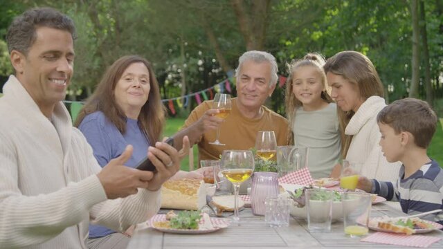 Handheld Shot of Family Taking Selfie During Al Fresco Dinner 02