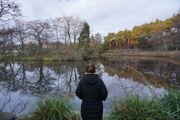 back view of woman looking at pond