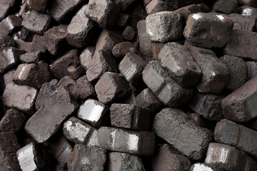 Closeup view of black charcoal, coal briquets. Coal texture background. Energy resource, heating, industrial use.