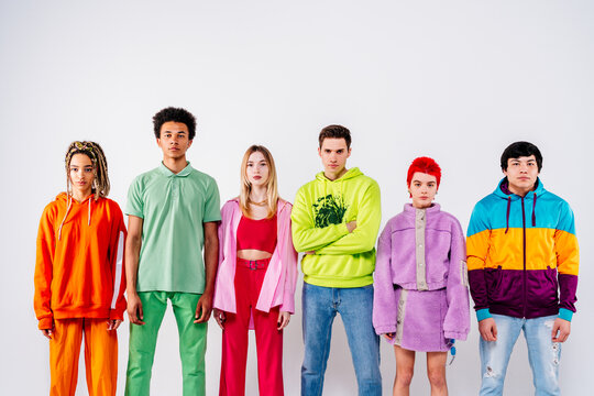 Stylish men and women in colorful clothes looking at camera against white background