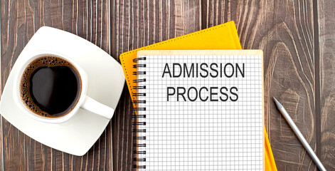 ADMISSION PROCESS text on the notebook with coffee on wooden background